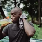Senior drinking water and wiping sweat